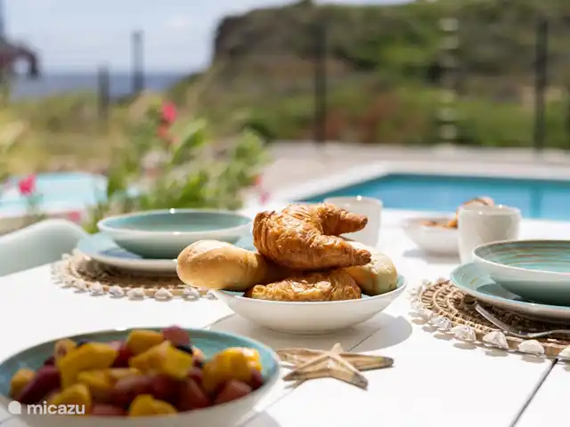 villa huren in Curaçao, Banda Ariba (oost), Vista Royal – Appartement Out of the Blue Ontbijten aan het zwembad met uitzicht op zee.