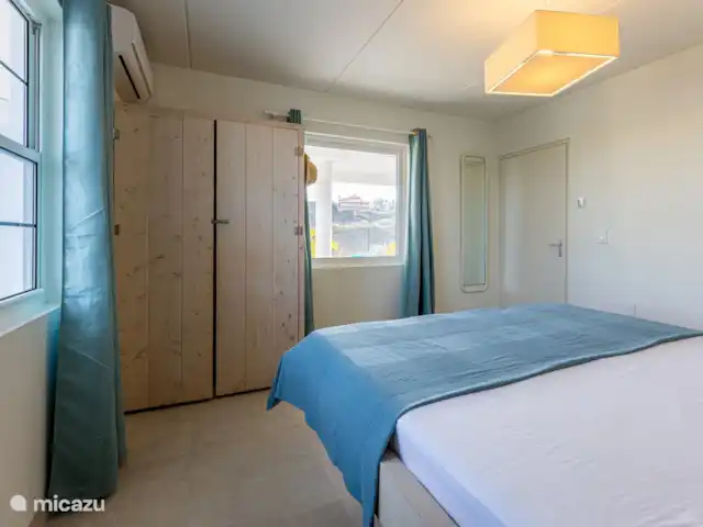 villa huren in Curaçao, Banda Ariba (oost), Vista Royal – Appartement Out of the Blue Benedenverdieping: Slaapkamer met uizicht op het zwembad en Caracasbaai/Zee.