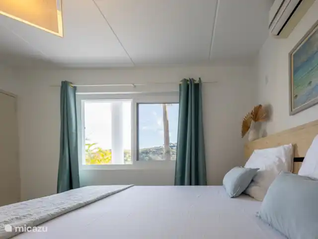 villa huren in Curaçao, Banda Ariba (oost), Vista Royal – Appartement Out of the Blue Benedenverdieping: Slaapkamer 2 met uitzicht op de tuin en zee.