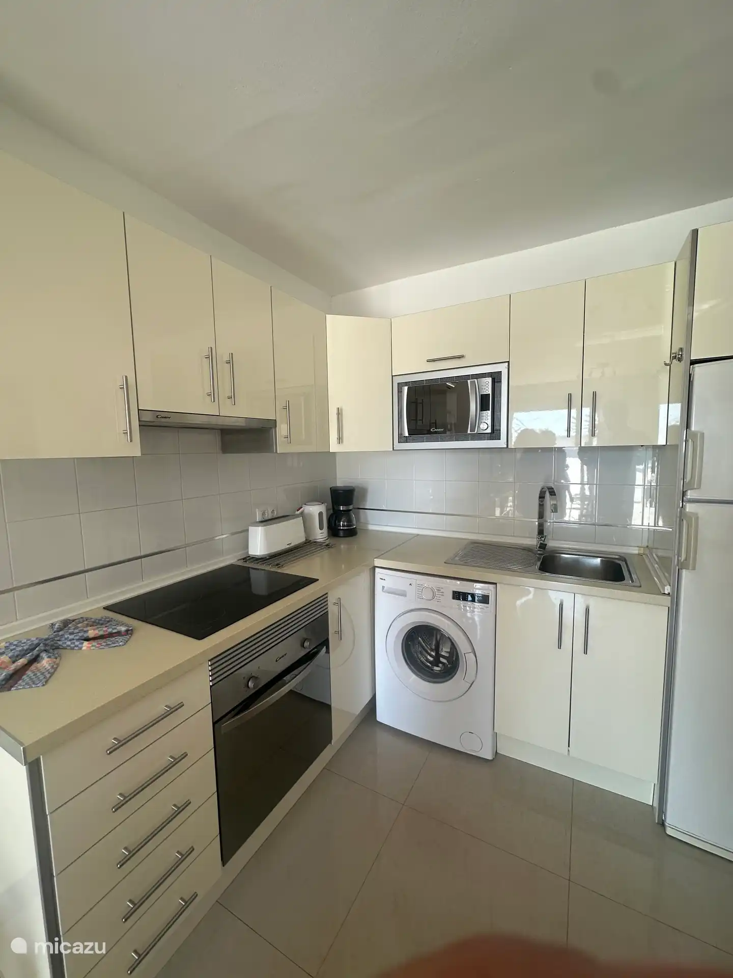 Cocina con lavadora, vitrocerámica, horno, nevera y microondas