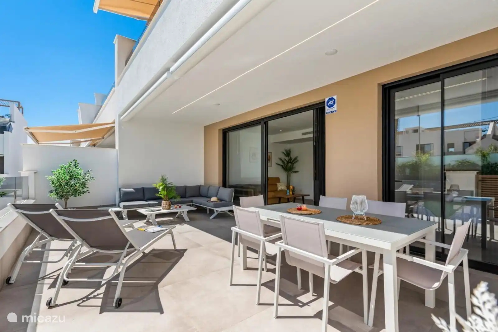 die Terrasse mit Esstisch und Lounge-Set 