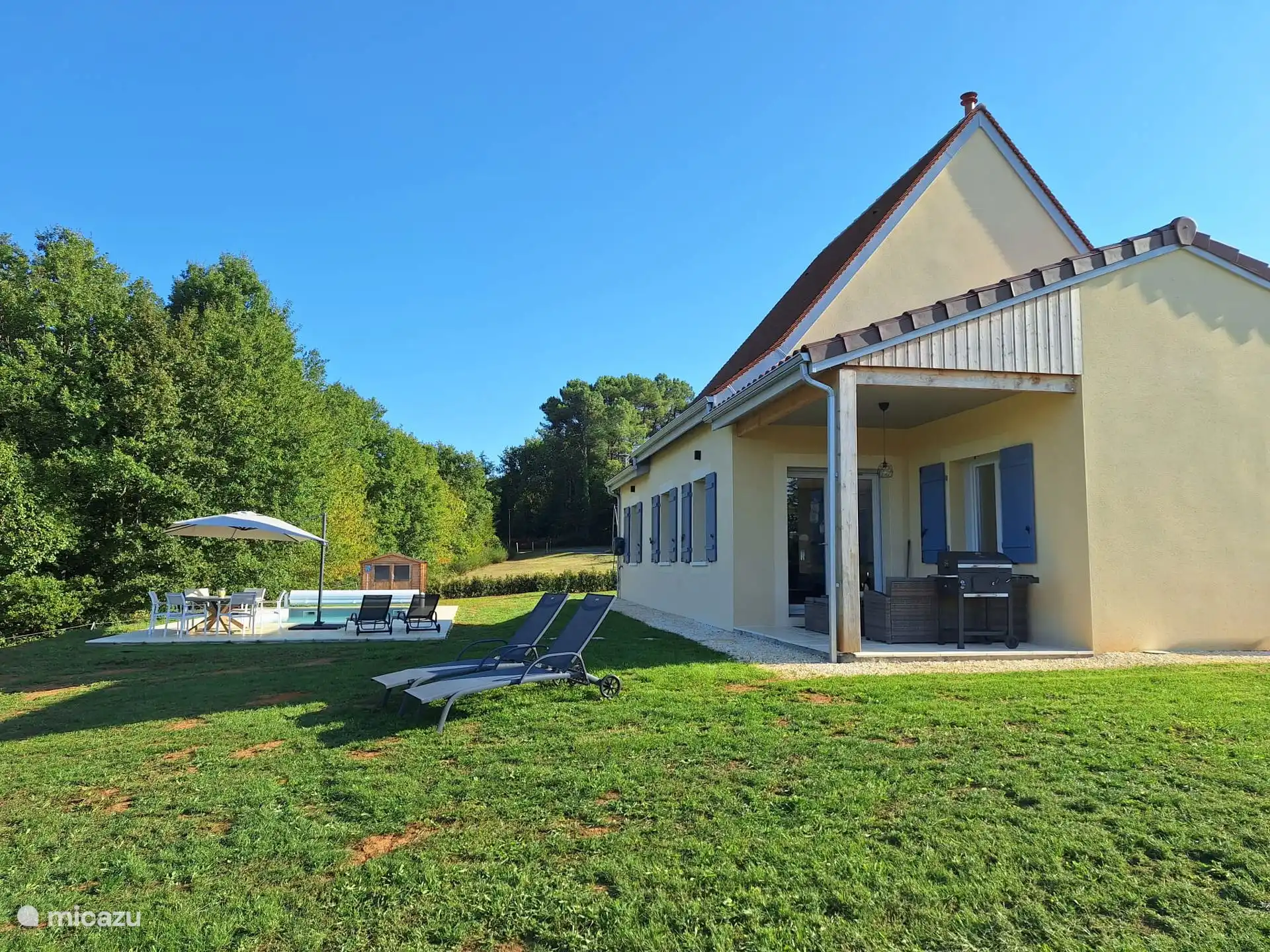 Suchen Sie sich den Schatten auf der Terrasse oder setzen Sie sich unter den Sonnenschirm auf der Terrasse am beheizten Pool
