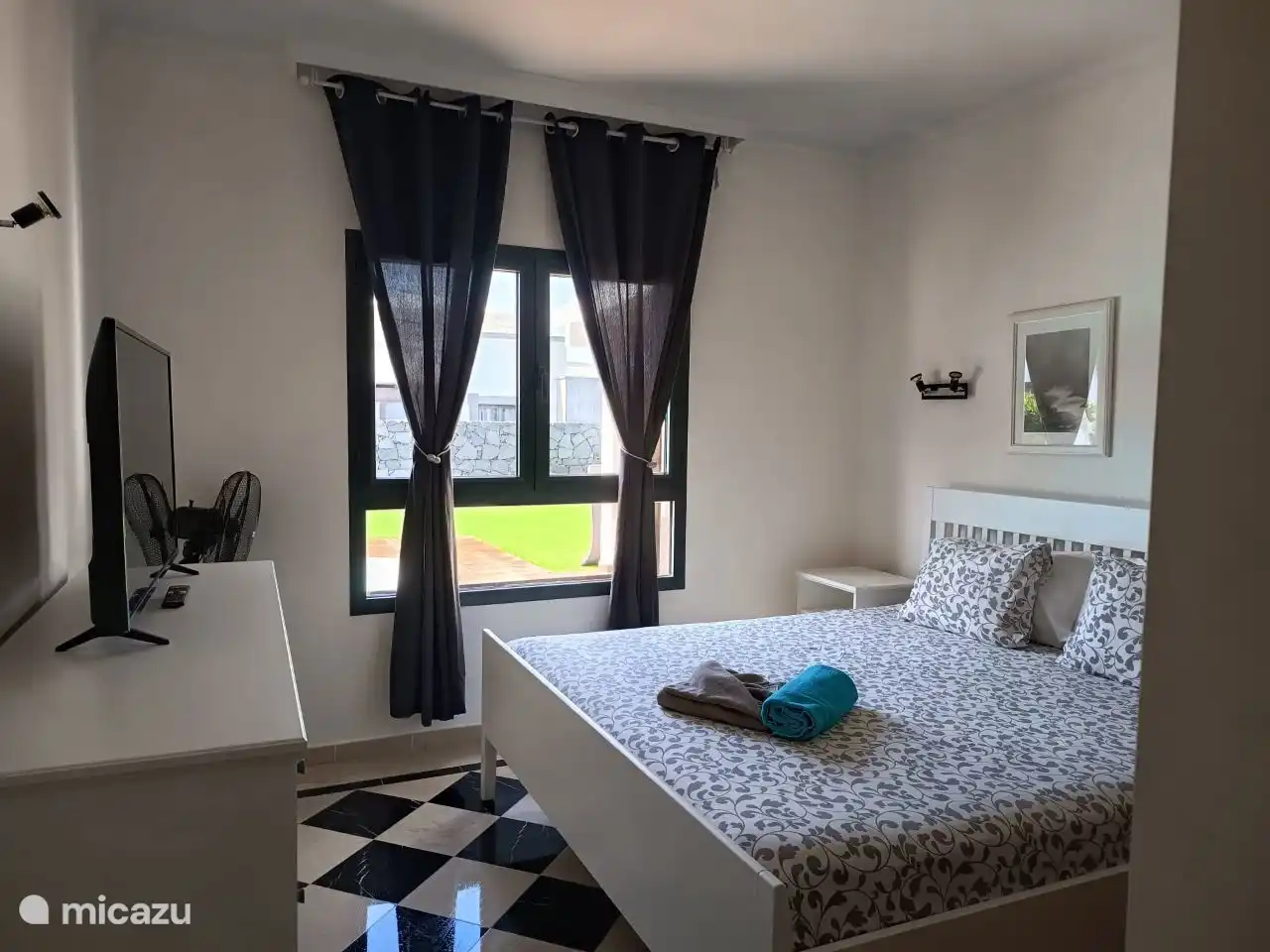 De tweede slaapkamer beschikt over een tweepersoonsbed, inbouwkasten en een mooi uitzicht op het zwembad.