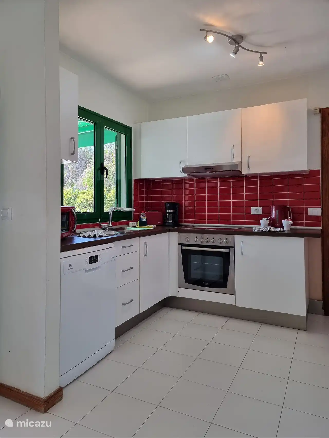 The kitchen with oven, microwave, dishwasher and coffee maker