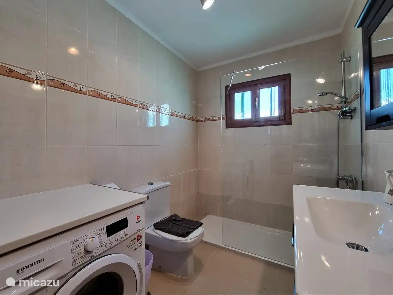 Bathroom with washing machine and toilet