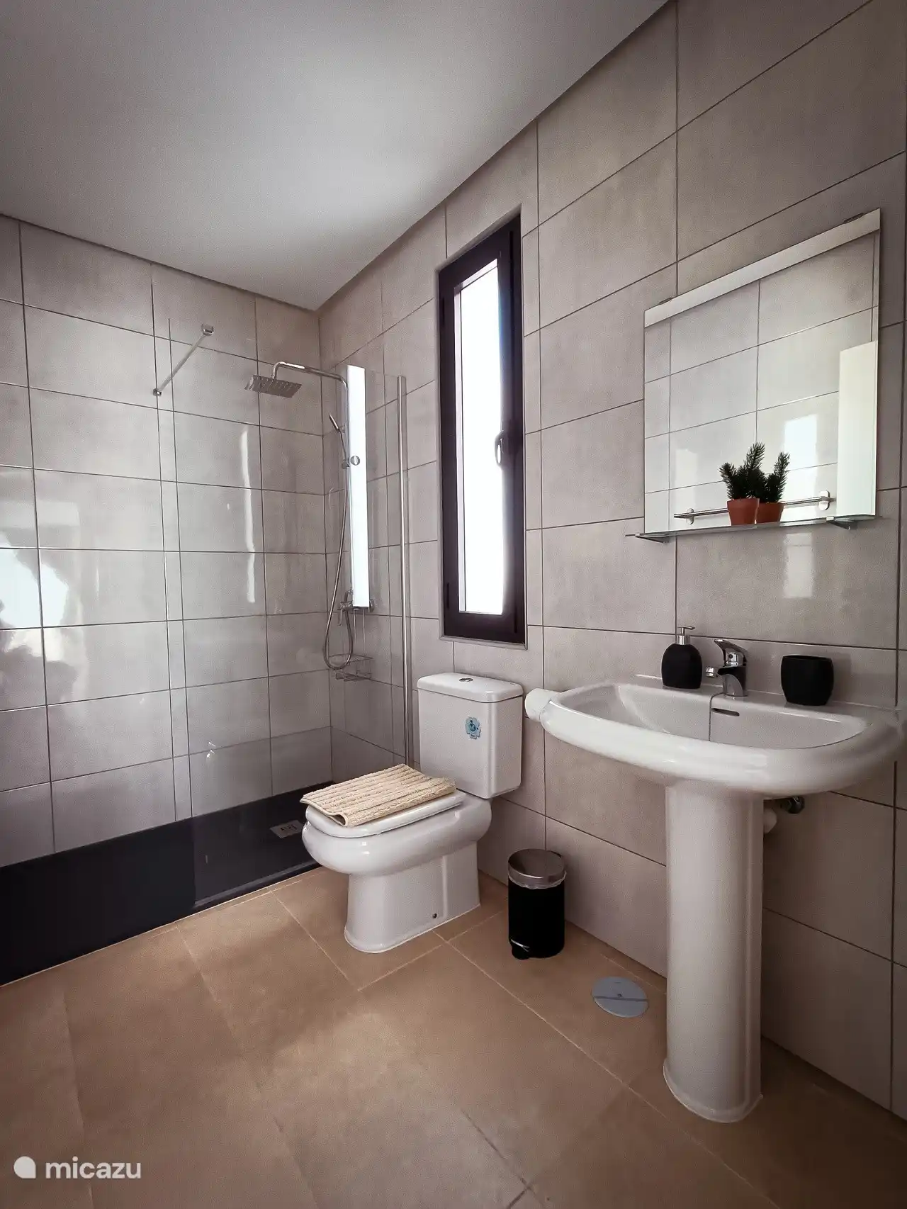 Adjoining bathroom to bedroom 2 with walk-in shower, toilet and sink.