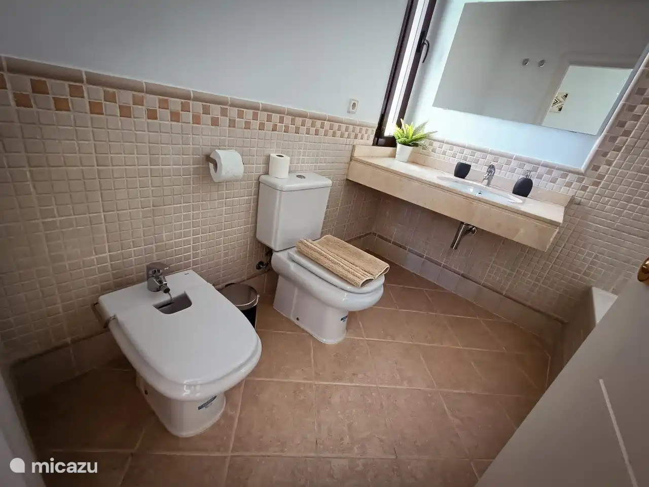 The bathroom with toilet, bidet, sink and bath