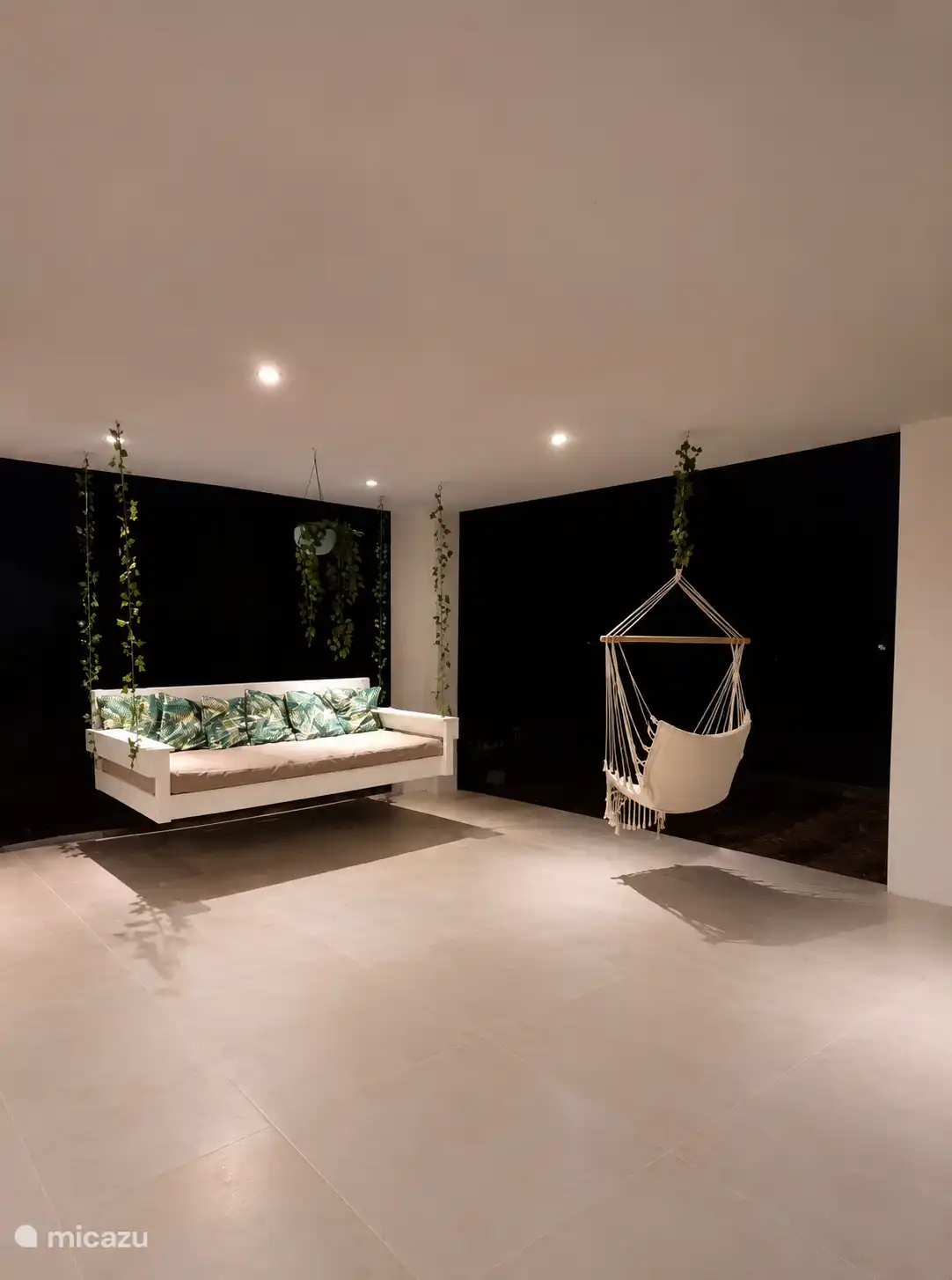 Ook in de avonduren is het heerlijk ontspannen op de overdekte veranda. Geniet van de rust en privacy op het sfeervolle zwevende loungebed of in de comfortabele hangstoel.