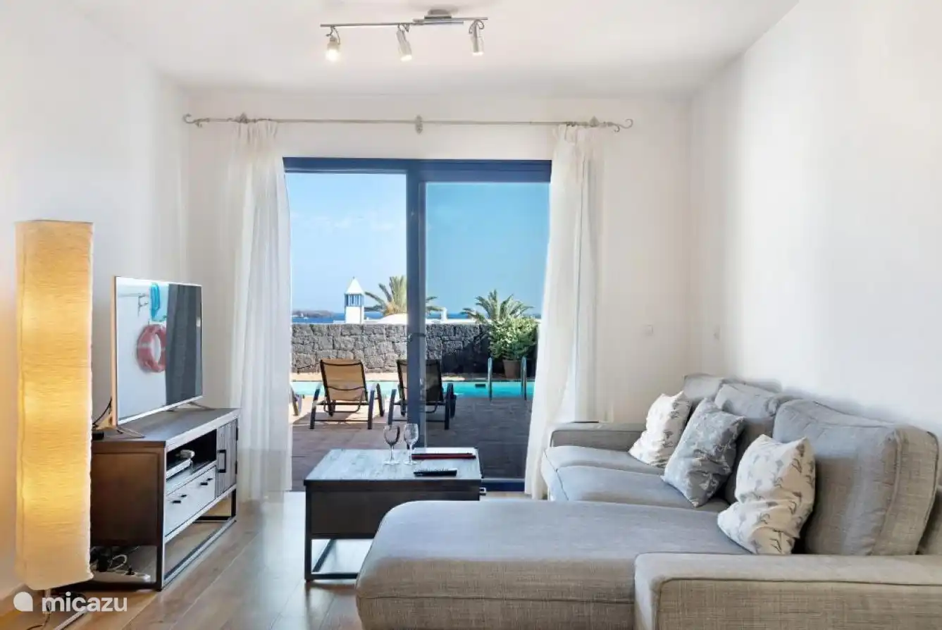 The living room with a nice corner sofa and direct access to the garden