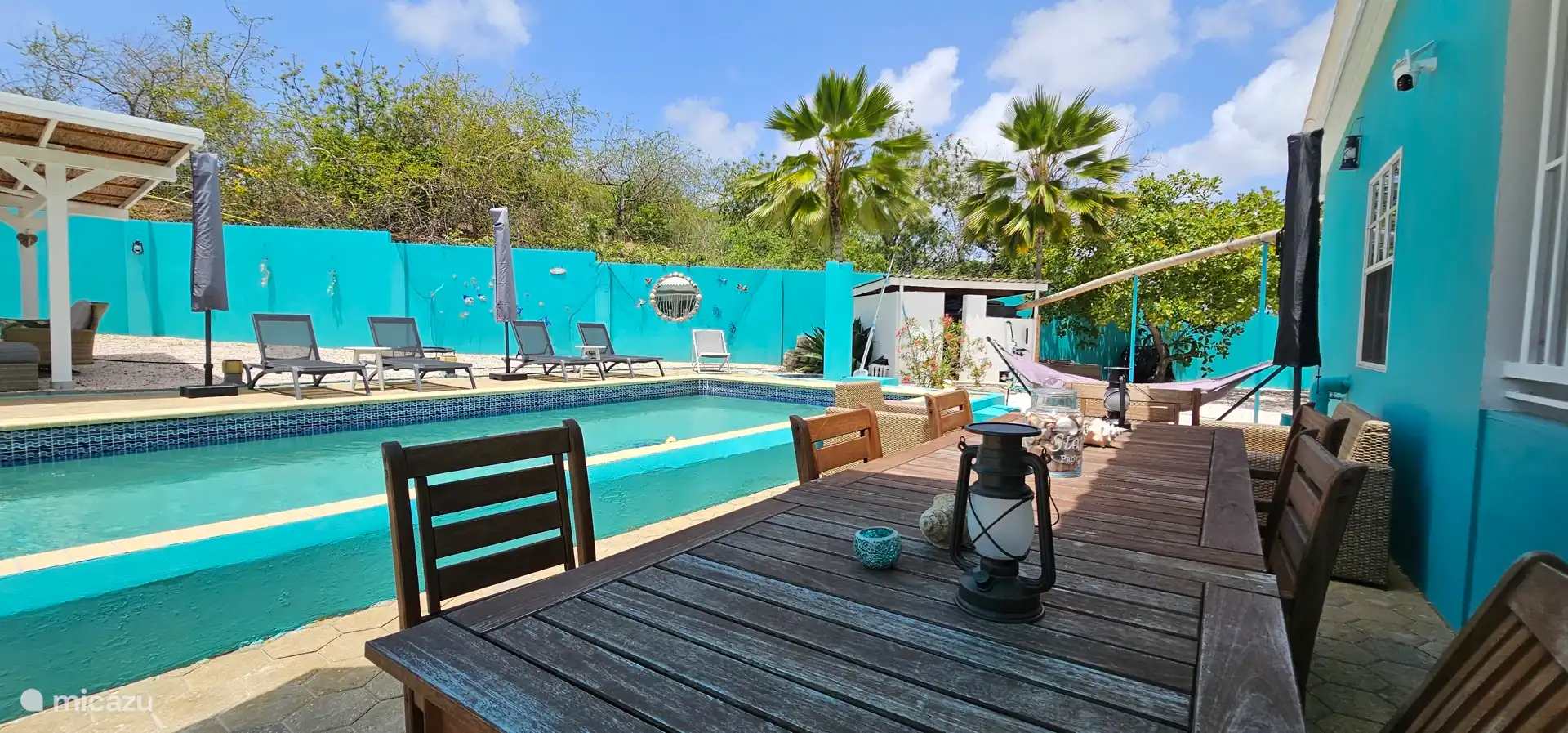 Swimming pool with lounge beds and large dining table