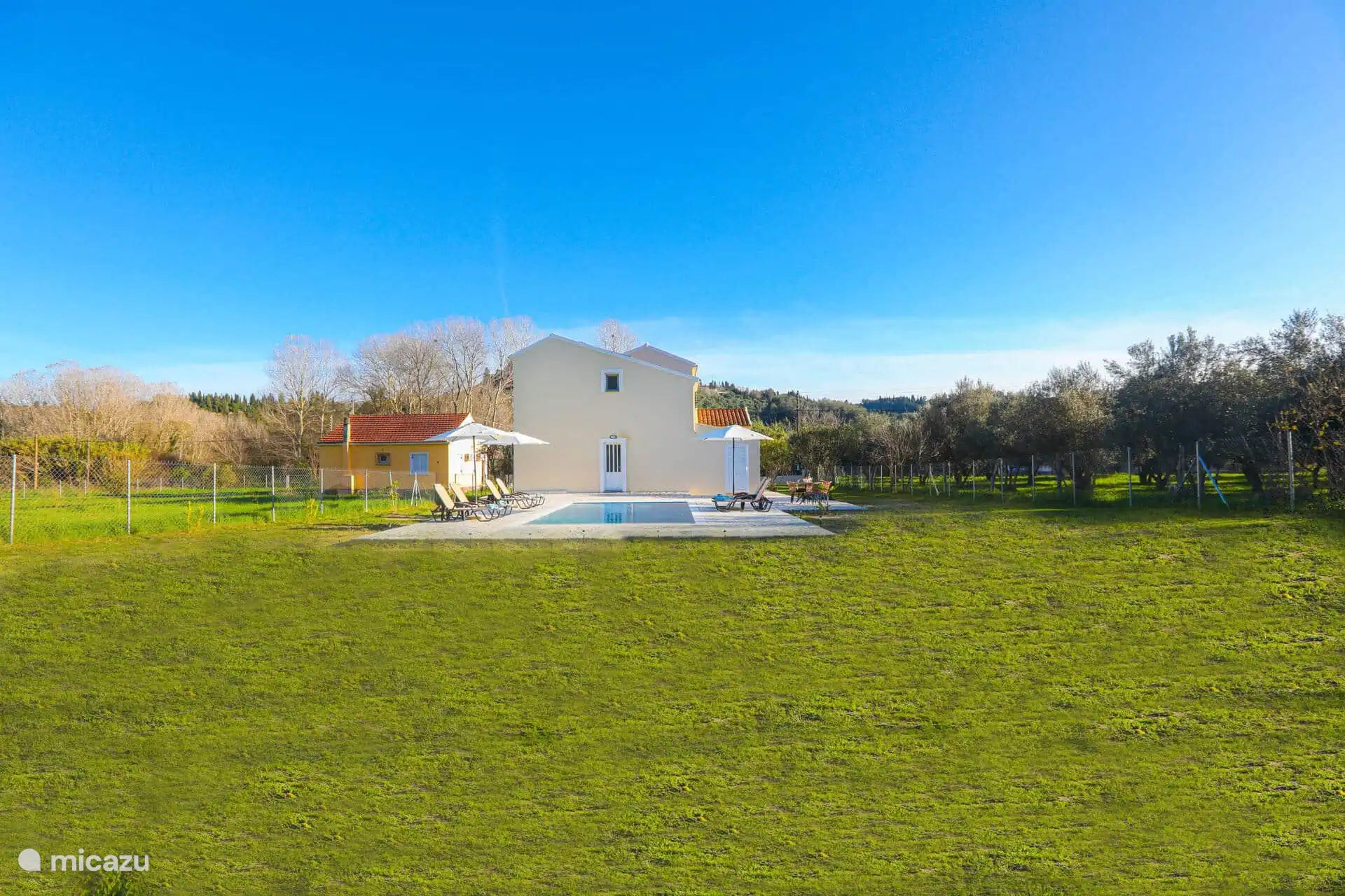 Arrière de la villa avec piscine privée et jardin clôturé 