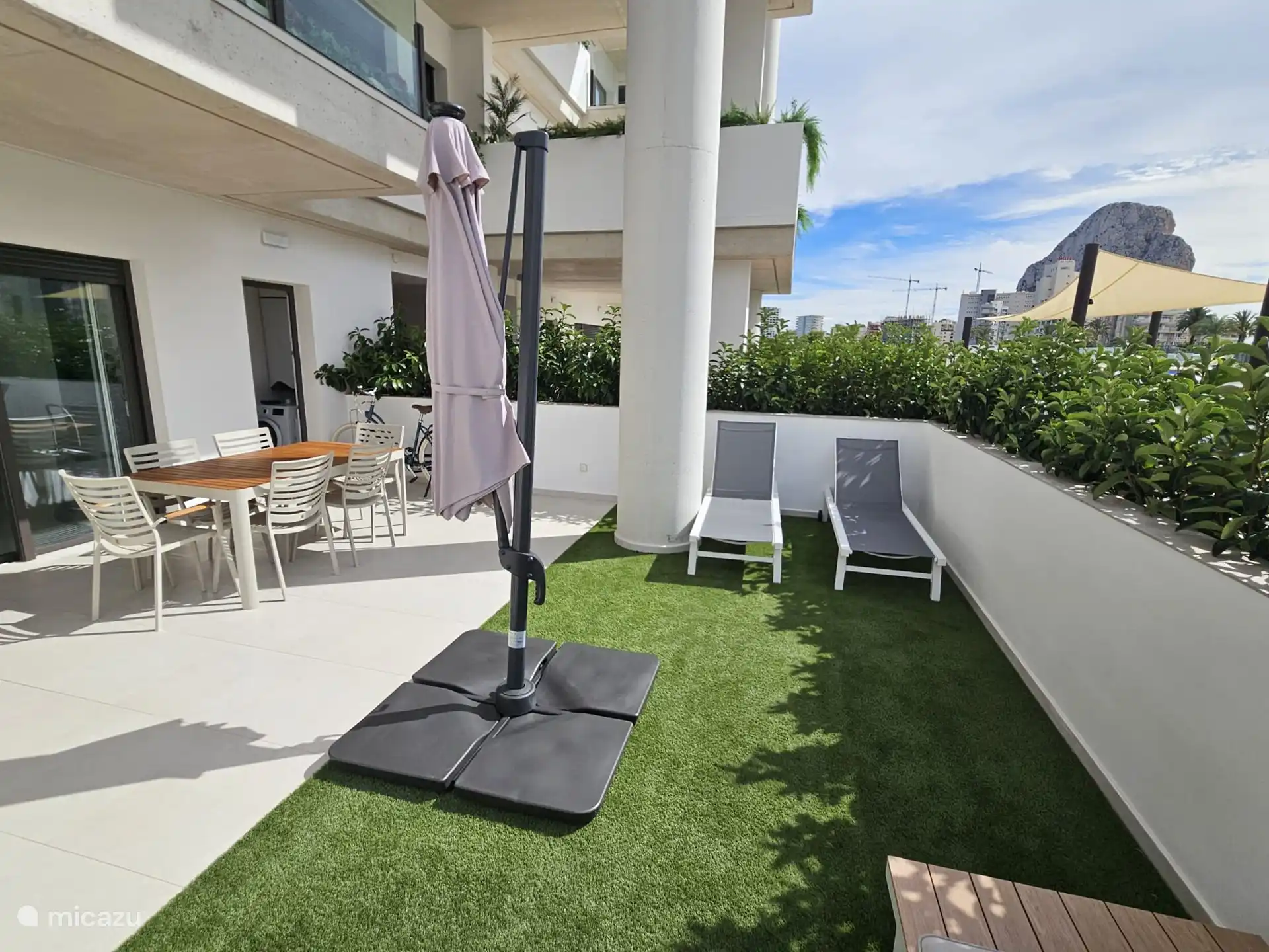 Terrasse spacieuse avec table et 6 chaises, 2 transats et salon avec parasol