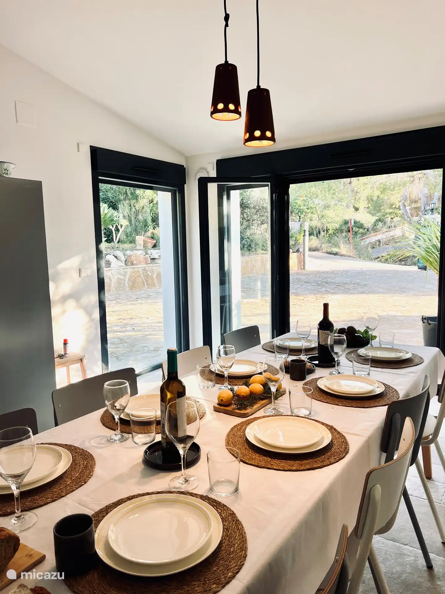 Die Innenküche grenzt an die Terrasse. Innen und außen gibt es große Esstische (also insgesamt drei)