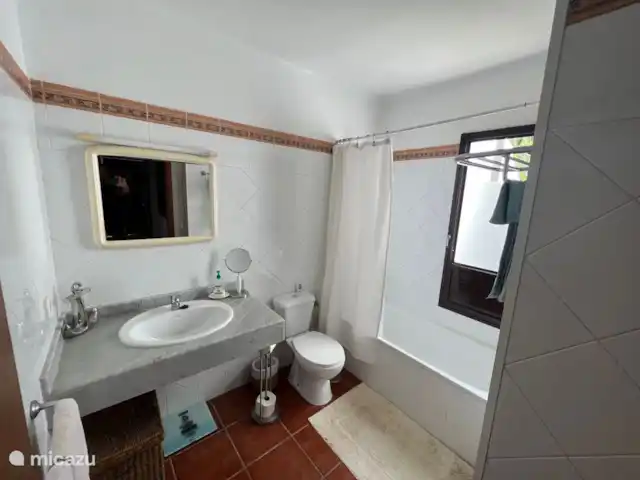 Villa Calamari | Espagne, Lanzarote, Playa Blanca - villa La salle de bain qui se trouve au bout du couloir dispose d’une baignoire avec douche, de toilettes et d’un lavabo.
