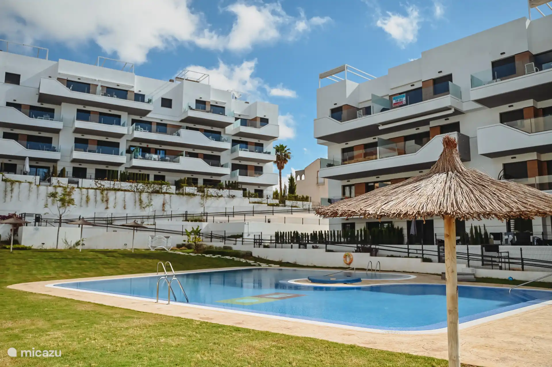 Zwembad met jacuzzi en gezellige parasols