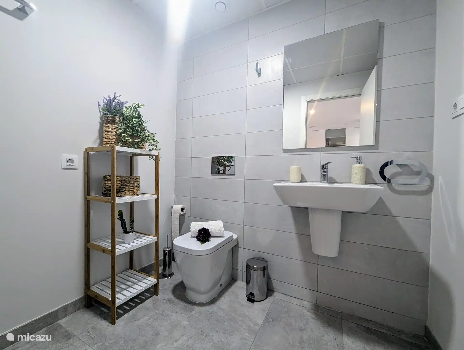 Belle salle de bain spacieuse avec douche, toilettes et lavabo.