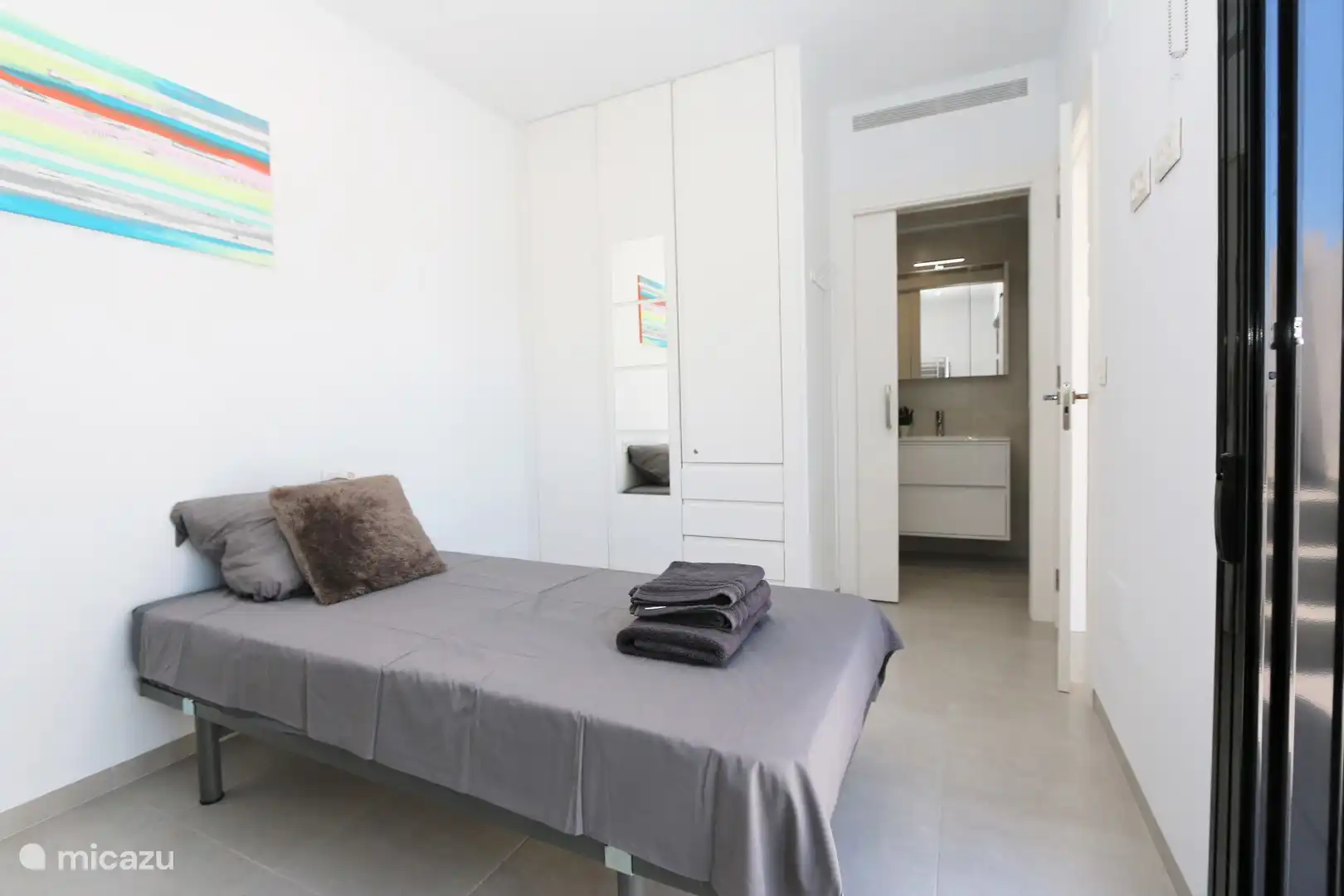 Schlafzimmer mit einem Einzelbett, Etagenbett und Badezimmer