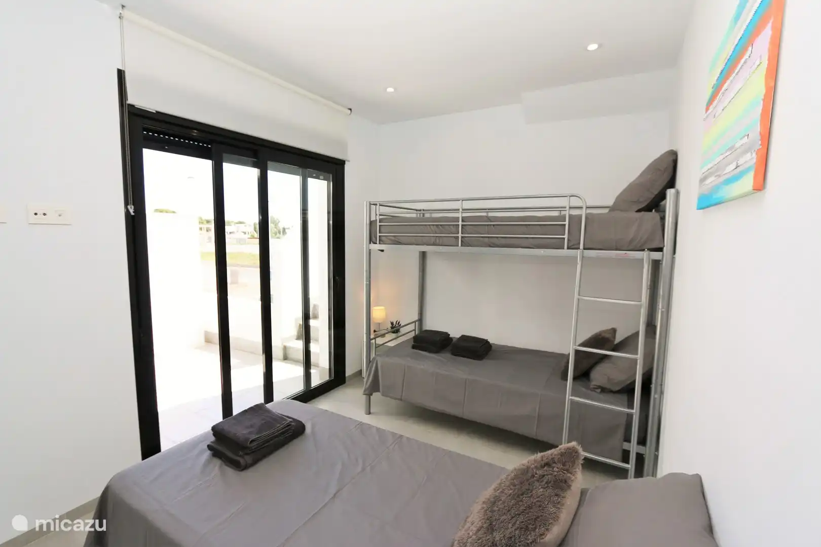 Schlafzimmer mit einem Einzelbett, Etagenbett und Badezimmer