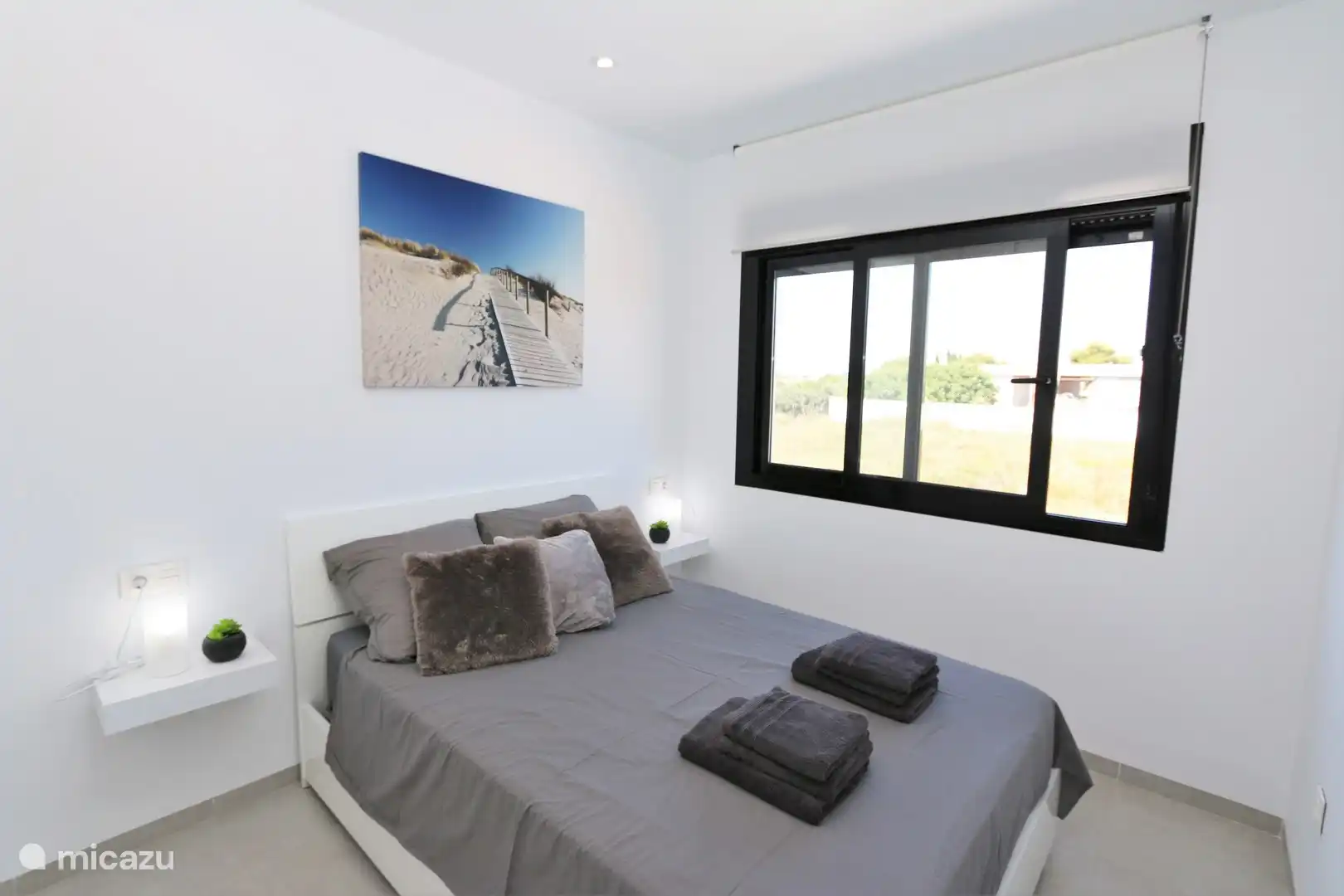 Schlafzimmer mit Doppelbett und Bad