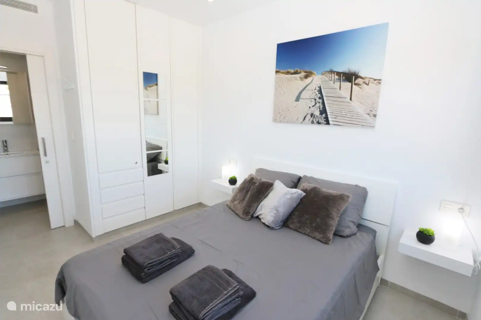 Schlafzimmer mit Doppelbett und Bad