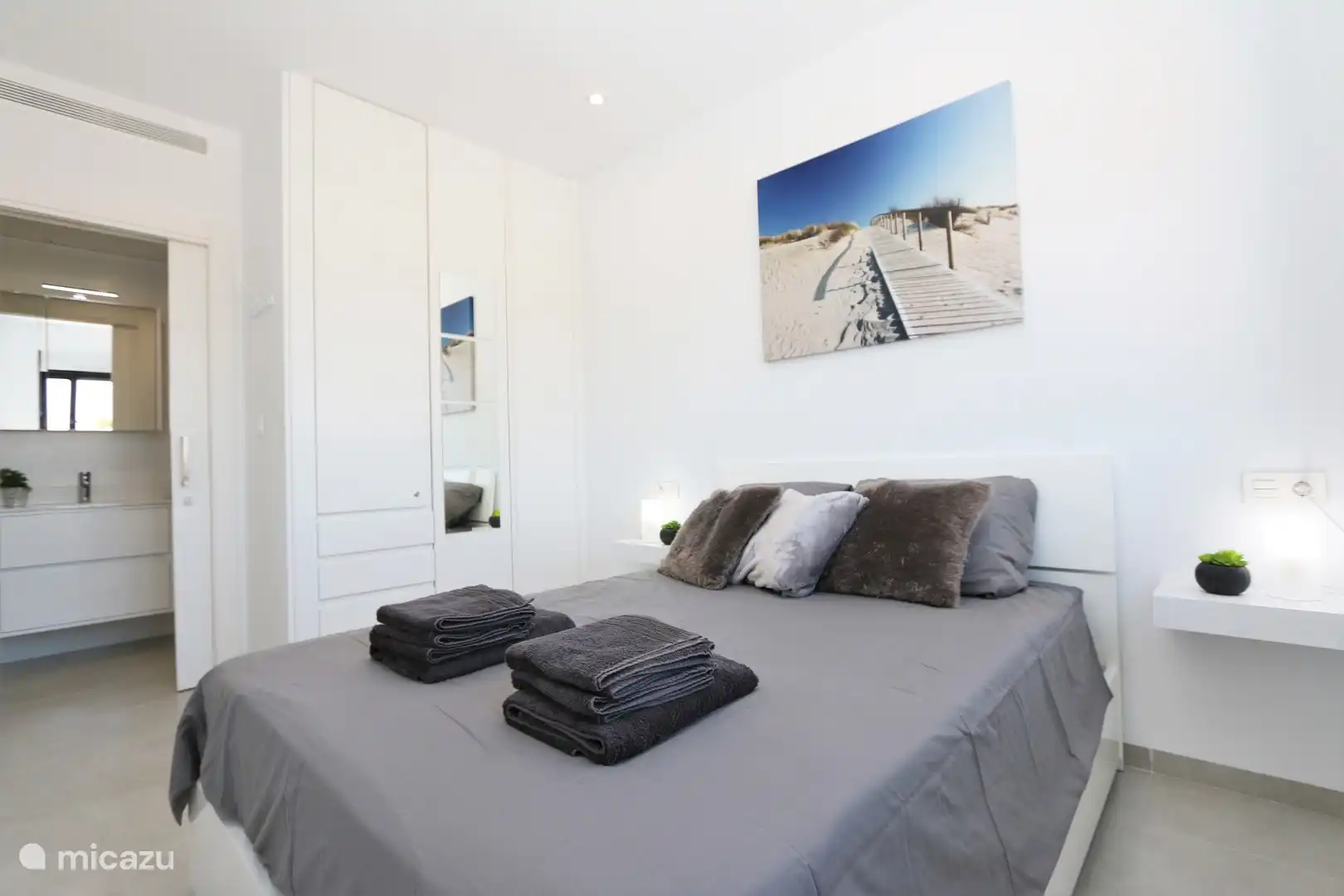 Schlafzimmer mit Doppelbett und Bad