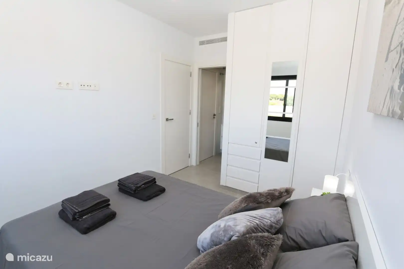 Schlafzimmer mit Doppelbett und Bad