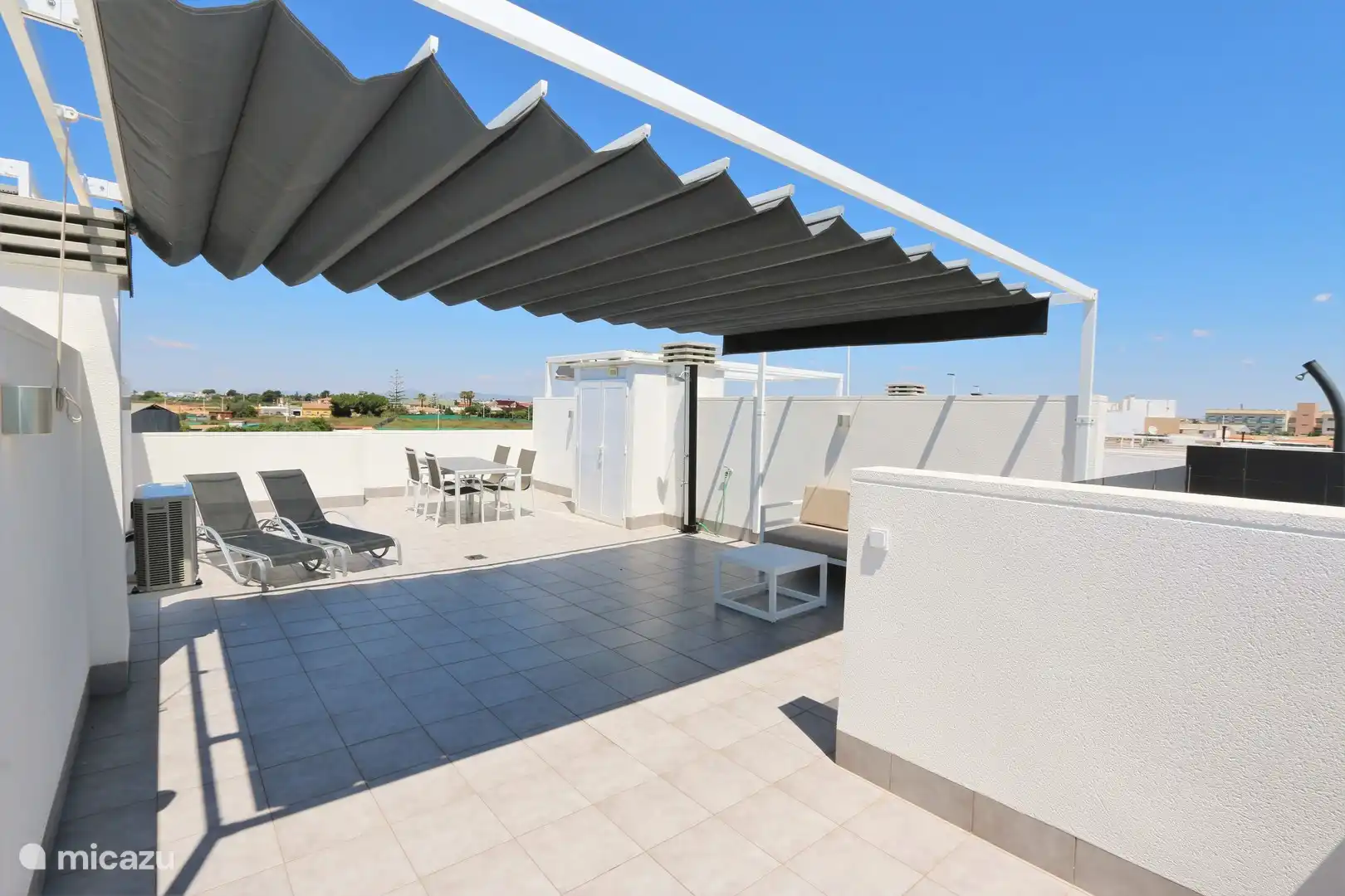 Dachterrasse mit Liegestühlen, Tischgarnitur und Sofa