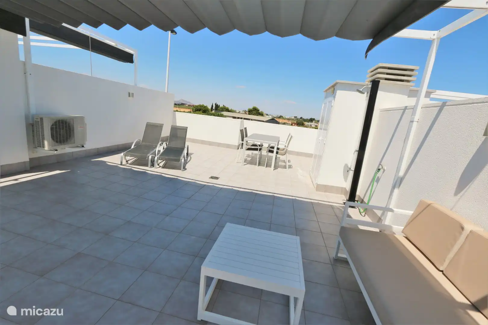 Dachterrasse mit Liegestühlen, Tischgarnitur und Sofa