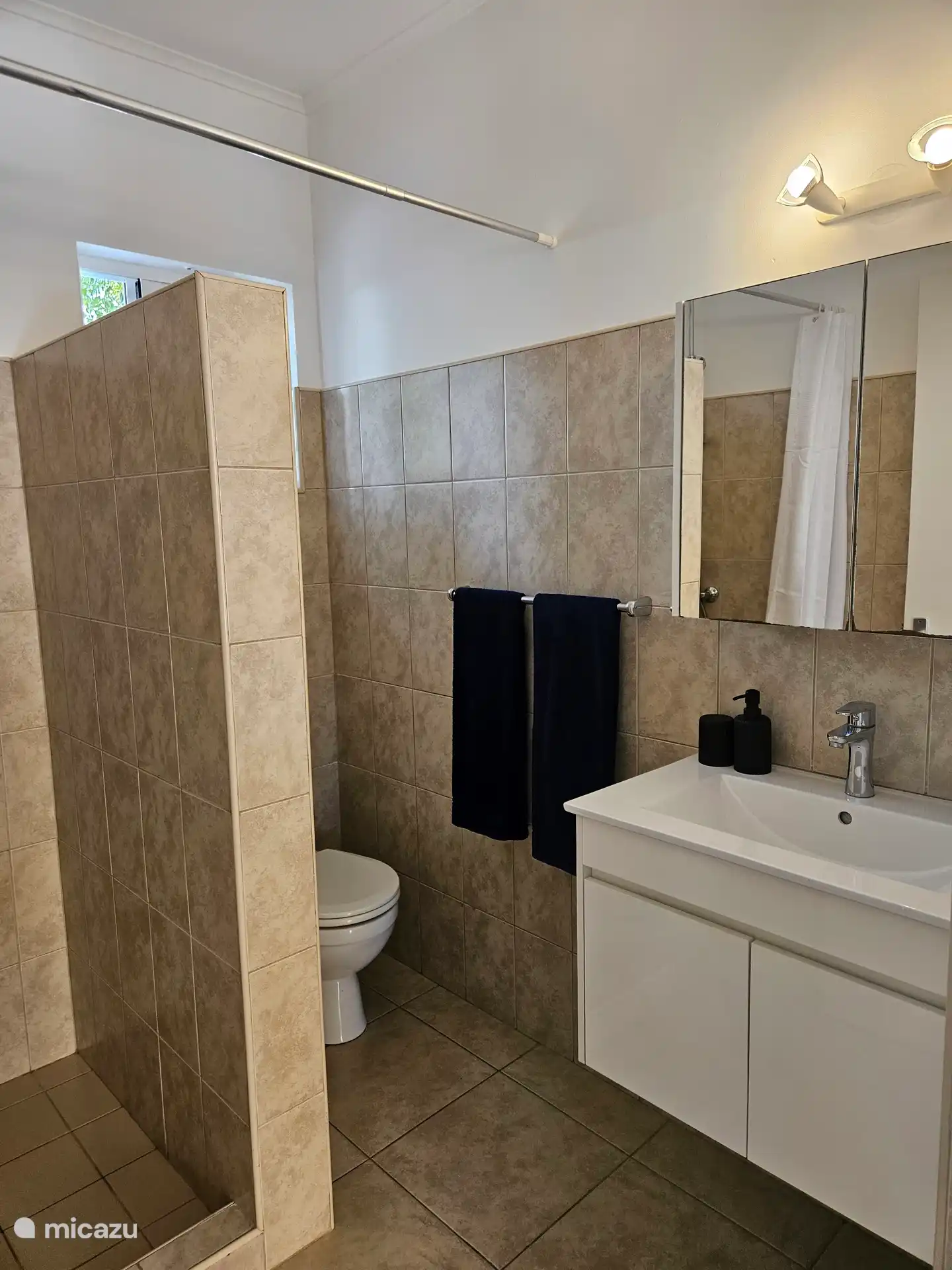 Badezimmer mit Dusche, Waschbecken und WC