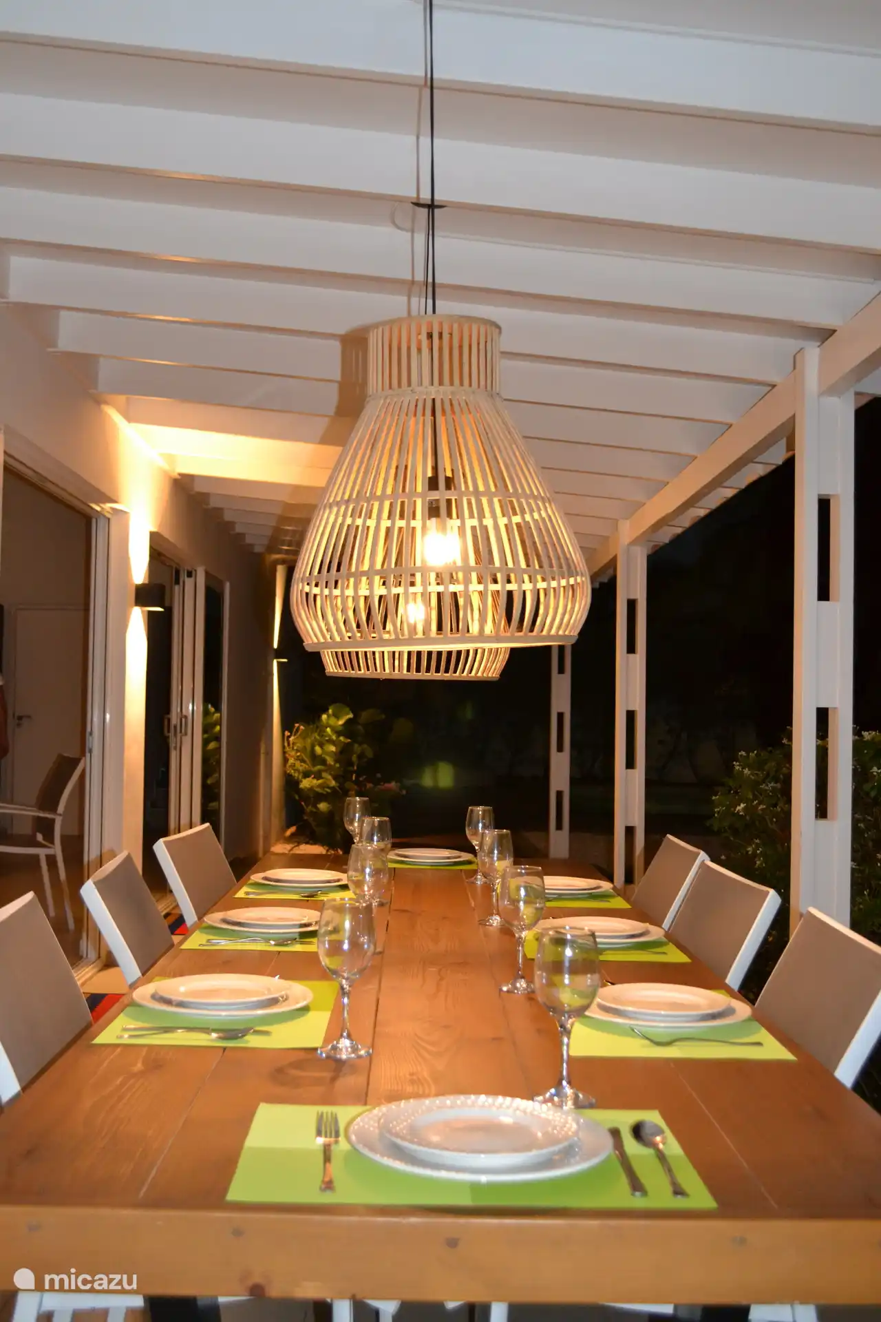 Terraza con mesa de comedor por la noche