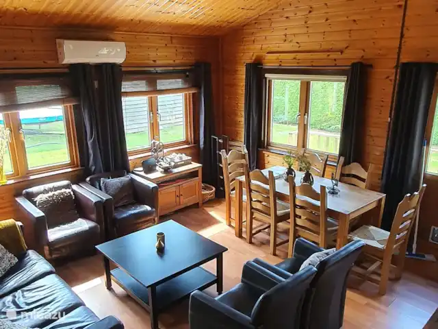 Casa finlandesa cerca de un gran lago en Países Bajos, Frise, Rohel - casa vacacional Una vista general de la habitación con preciosos sillones y sofá de 3 plazas y la zona de comedor.