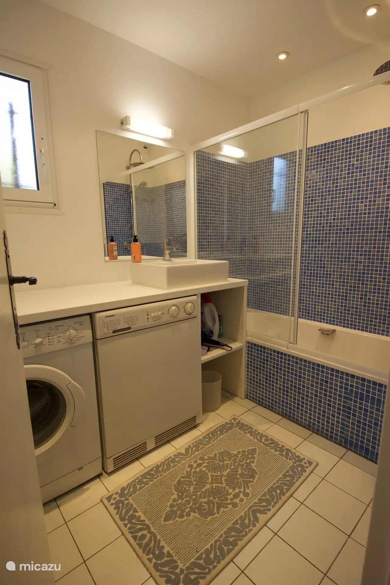 Badezimmer mit Dusche, Badewanne, Waschmaschine und Trockner