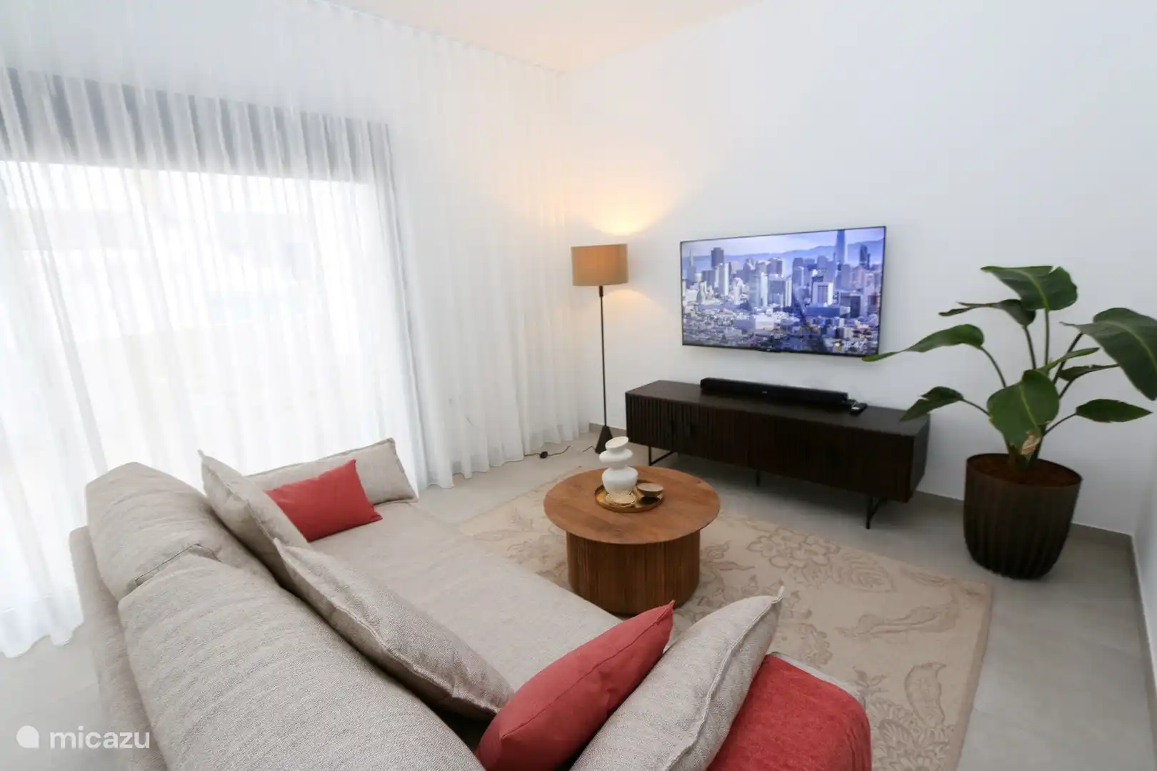 Comfortable sofa in the living room with large Smart TV.