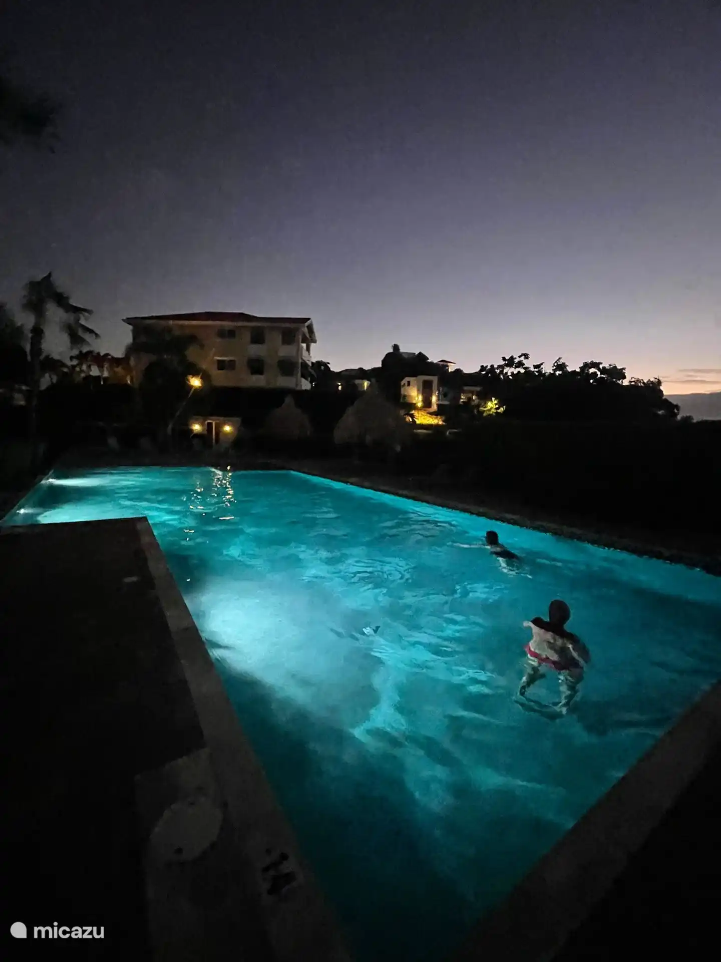 Verlicht zwembad in de avond en nacht.