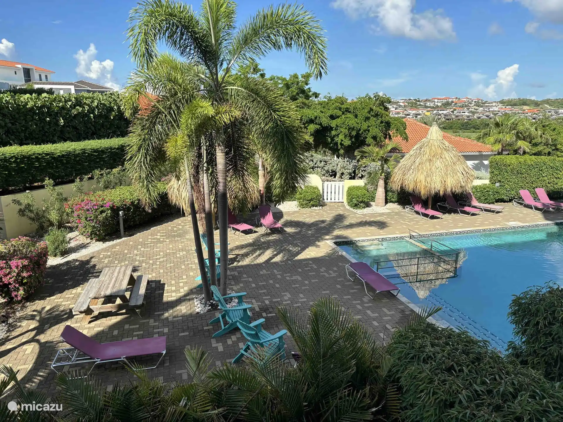 Bij het zwembad zijn bedjes en parasols.