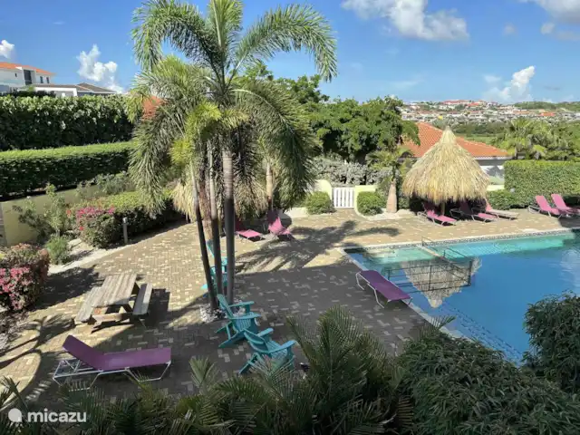 Location de Vacances Curaçao, Curaçao-Centre, Sint Michiel, appartement - Blue Bay Triple Arbre 'La Colline' Il y a des lits et des parasols au bord de la piscine.