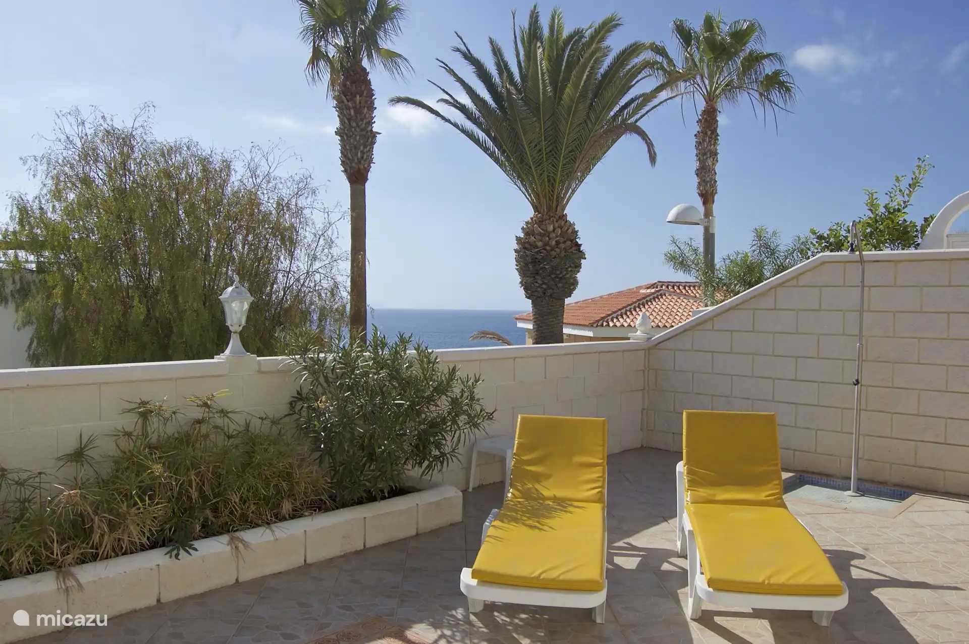 Bequeme Sonnenliegen mit Meerblick und Außendusche