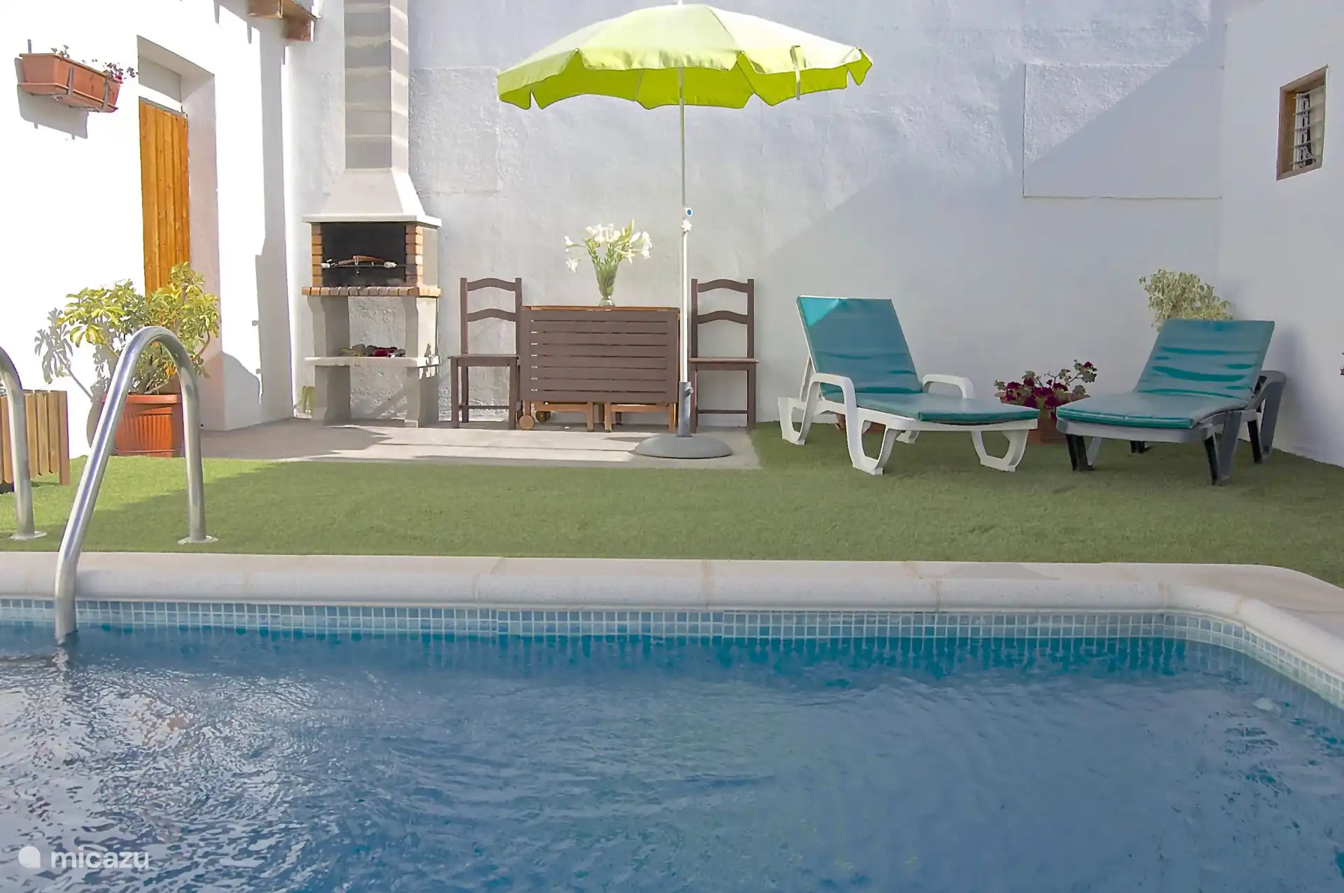 Es gibt auch Sonnenliegen und einen Grill mit Esstisch und Stühlen