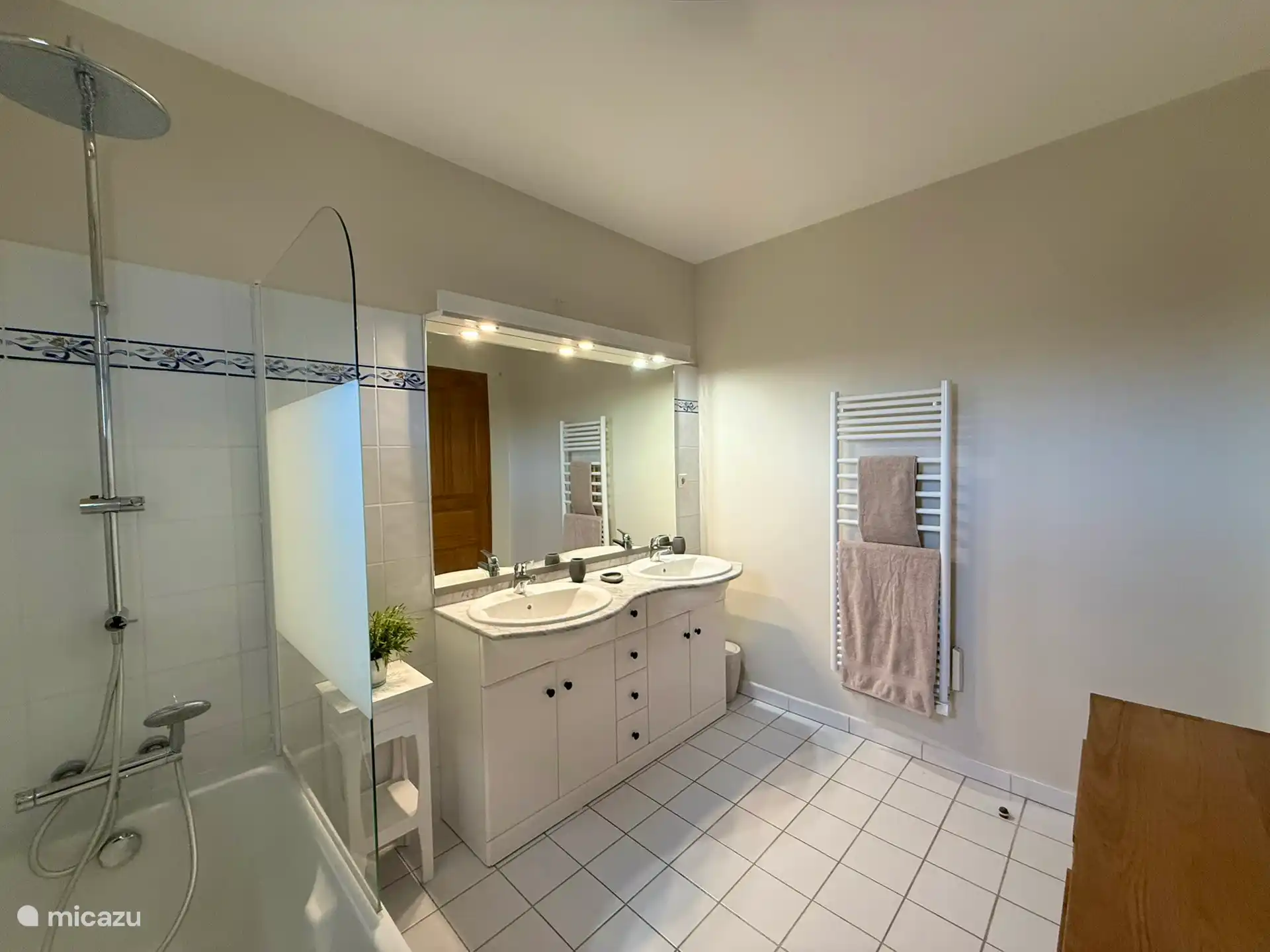 Badezimmer mit zwei Waschbecken und einer Badewanne, die auch als Dusche genutzt werden kann.