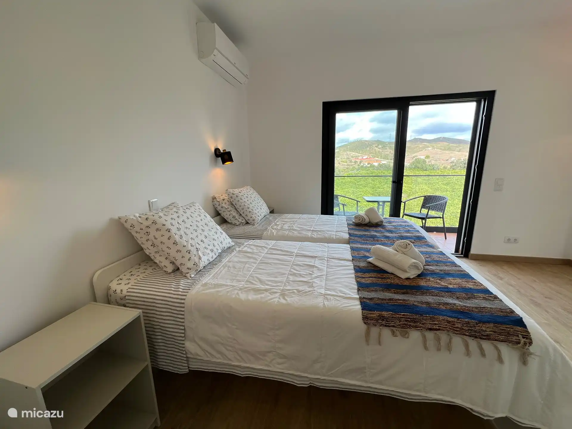 Schlafzimmer mit zwei Einzelbetten, das über ein eigenes Bad verfügt