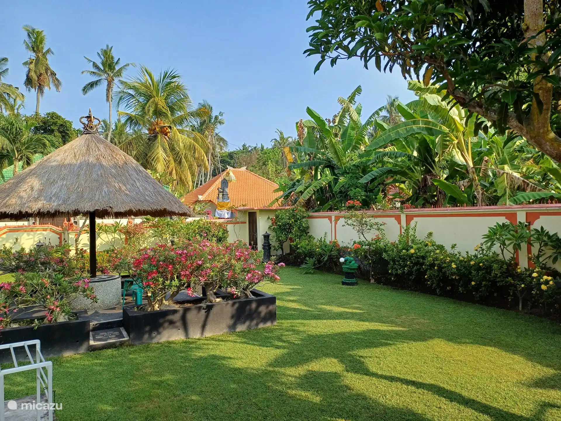 Terrasse im Garten unter Sonnenschirm.