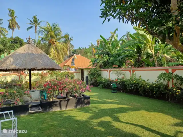 Jasri Villa Loen | Indonésie, Bali, Jasri Pantai - bungalow Terrasse dans le jardin sous parasol.