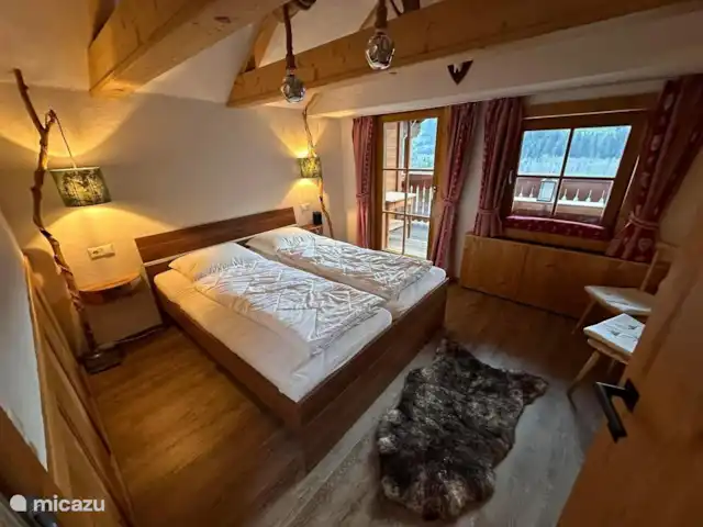 Chalet Murmel huren in Oostenrijk, Karinthië, Grosskirchheim - vakantiehuis De slaapkamer met balkon met rondzit op het zuiden. Geweldig uitzicht en heerlijk in de zon. Let op het zwaluwennestje achter de speaker.