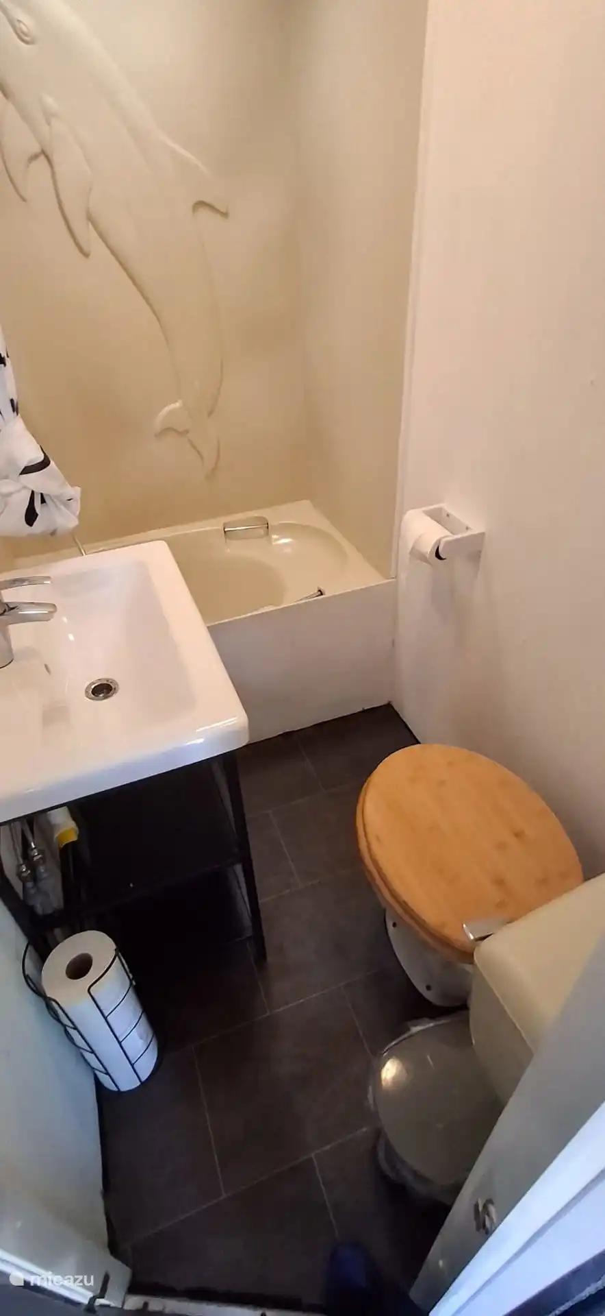 Badezimmer mit WC, Waschbecken und Dusche, Toilettenpapier ist vorhanden 