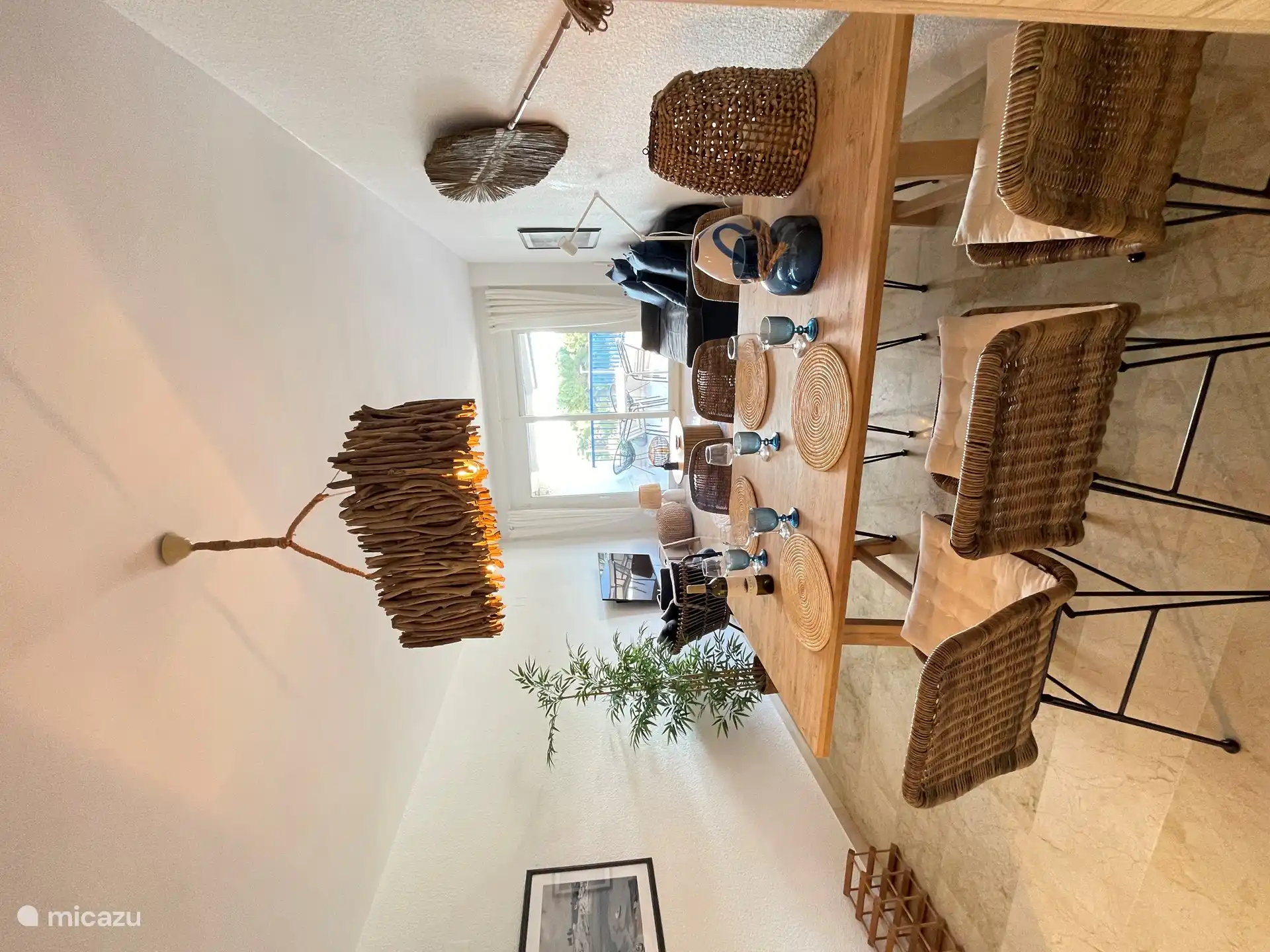 Gemütliches Wohnzimmer mit Sitzecke und geräumigem Esstisch, an dem bis zu 6 Personen sitzen können. Das Wohnzimmer ist hell durch die großen Schiebetüren zum Balkon mit Blick auf den Park und das Meer.