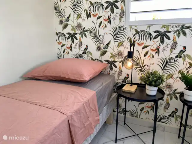 Kas Son i Mar met prive zwembad huren in Curaçao, Banda Abou (west), Fontein - villa Sfeervol detail van het bed met tropisch behang en fris bedlinnen – een rustgevende mix van comfort en Caribische stijl