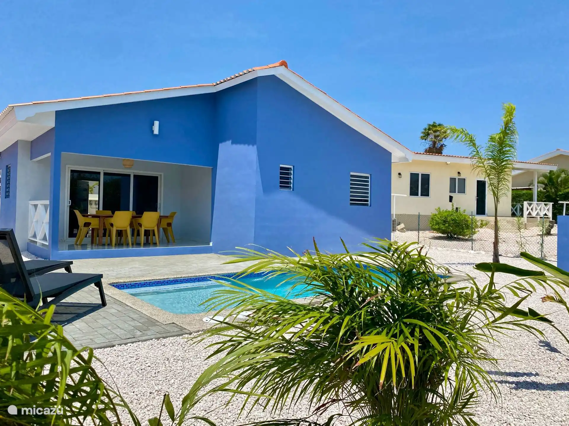 Jardin tropical coloré avec piscine privée et grande terrasse de piscine avec transats - parfait pour les familles pour se détendre, jouer et profiter du soleil ensemble.