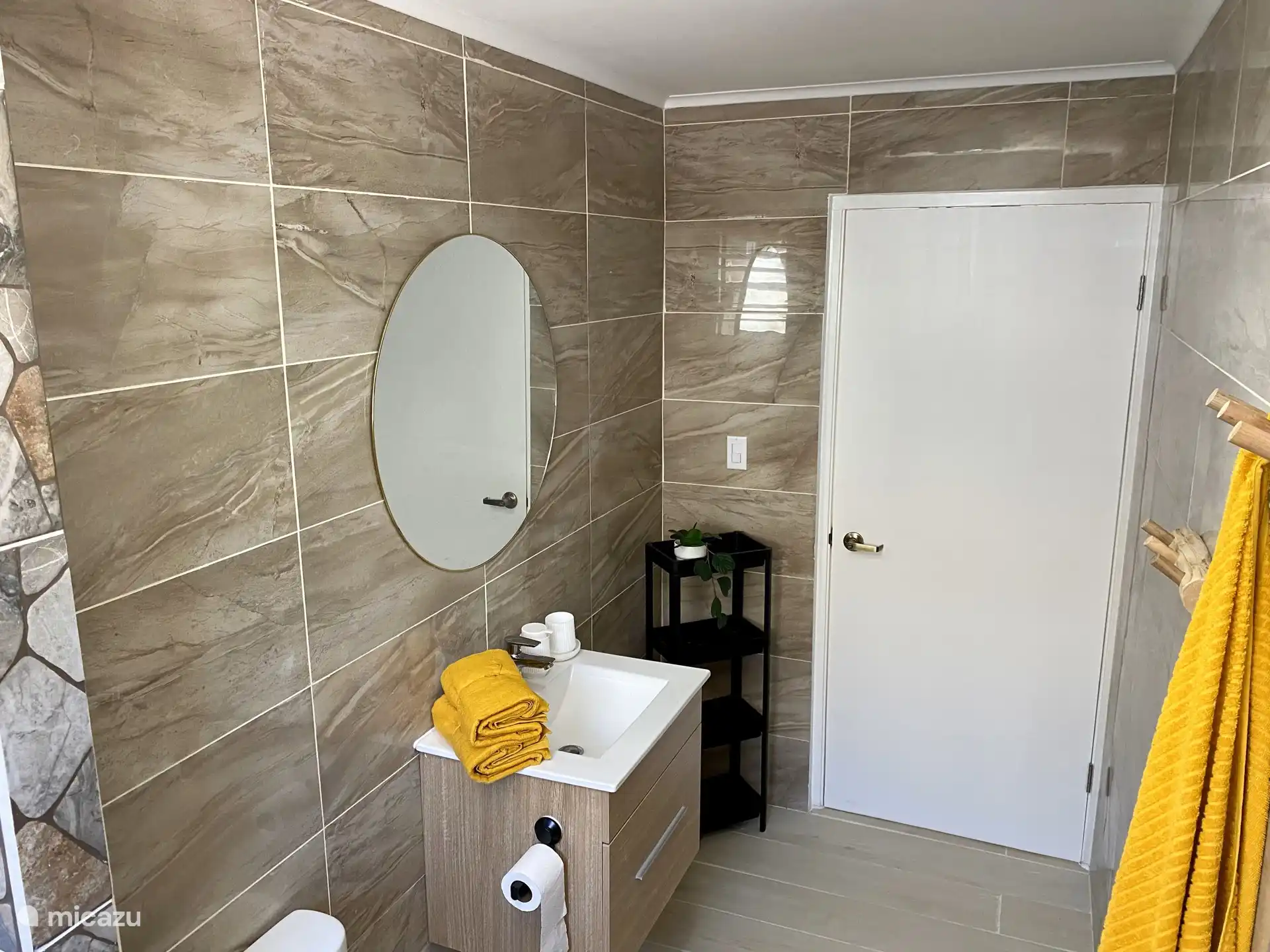 Salle de bains élégante avec lavabo moderne, grand miroir et porte-serviettes pratique - parfait pour votre rafraîchissement quotidien.