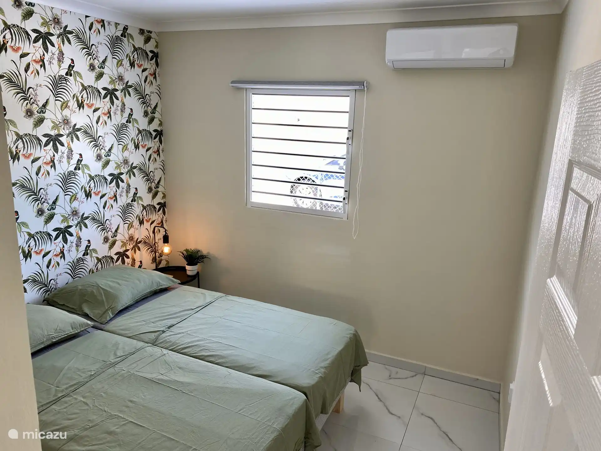 Chambre avec deux lits simples et climatisation, idéale pour les enfants ou les amis.