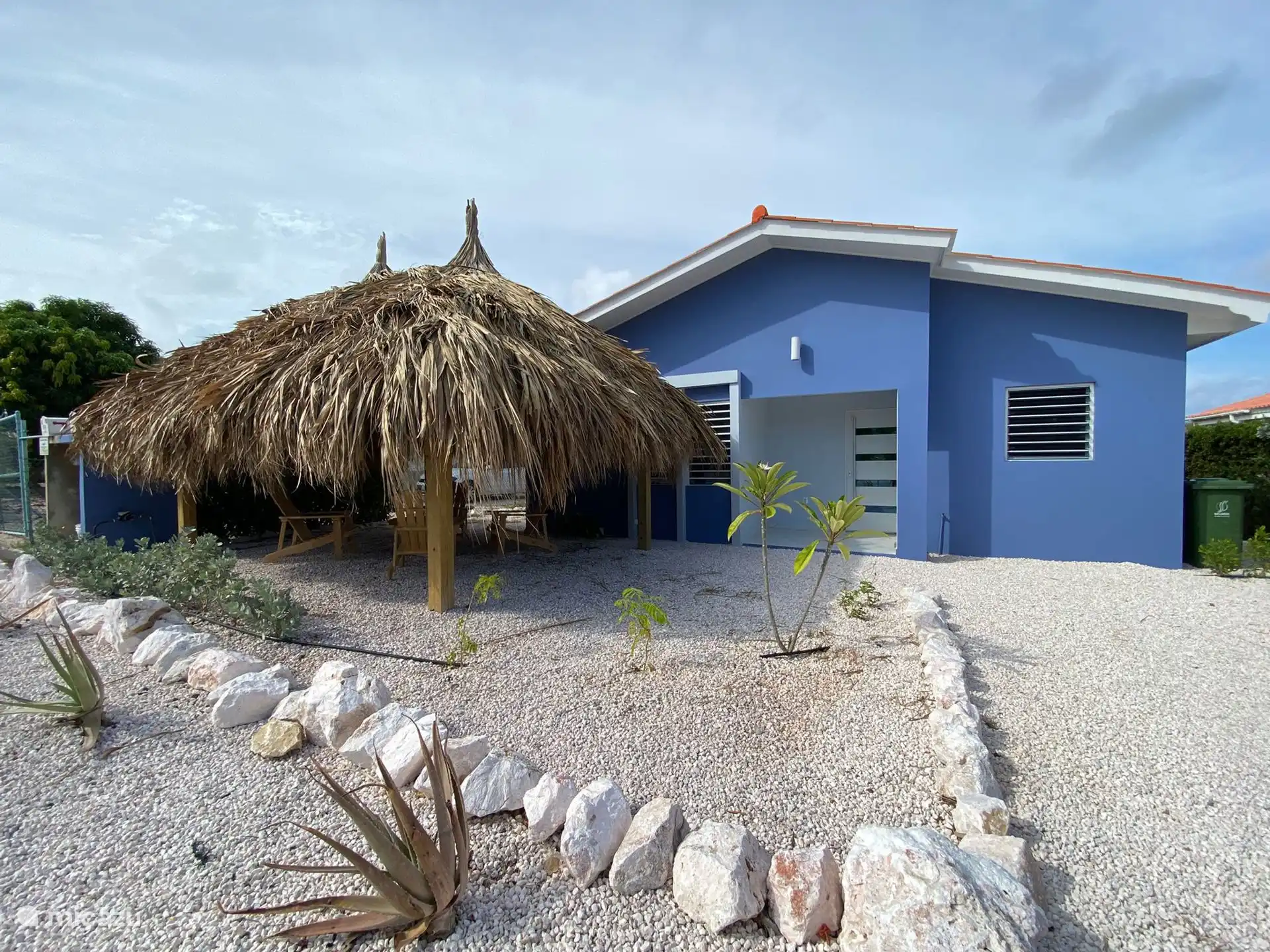 Vue de face de la villa avec allée privée et un salon confortable situé sous la palapa - un endroit charmant pour se détendre au soleil du soir ou dans la brise des Caraïbes.